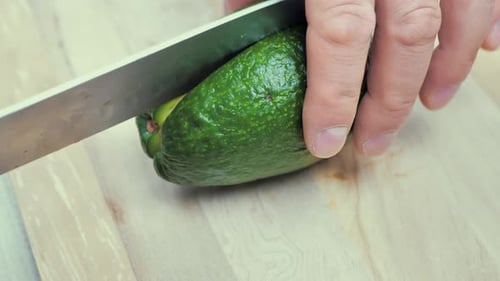 Un hombre corta un aguacate