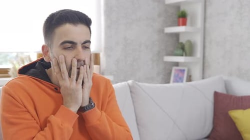 Worried Man Sitting on Couch with Anxiety