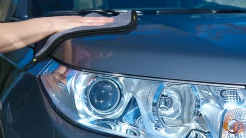 Hand Wipes Down a Car with Cloth