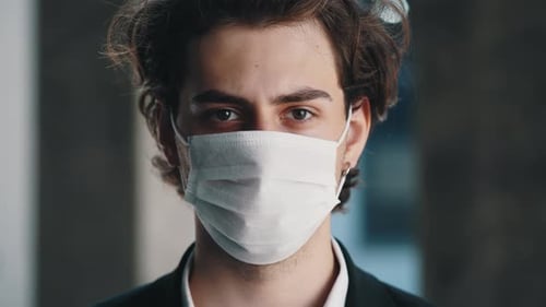 Portrait of the Caucasian Businessman Wearing Mask in Formal Suit Standing Near the Business Centre