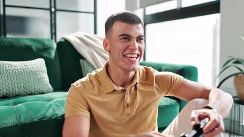 Man Smiling While Playing Video Game at Home