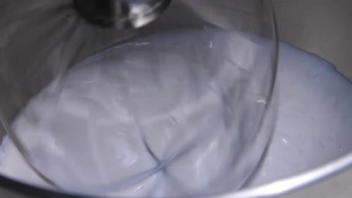 wisking cream in mixer cream egg making cream closeup top view.