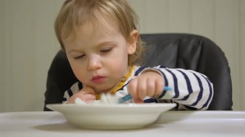 Child Eating Cereal from Bowl with Spoon