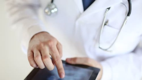 Doctor Examines Medical Scan on Tablet Computer