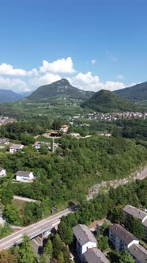 Aerial view of village surrounded by mountains and forest, Italy.