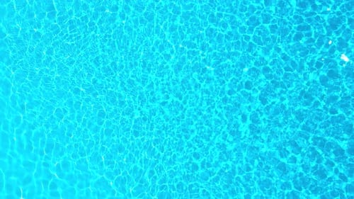 Blue Water in the Swimming Pool with Light Reflections