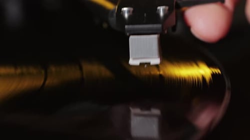 Record Player Arm Placed on Spinning Vinyl Record