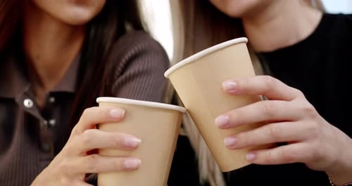 Young Women Enjoying Coffee on Street