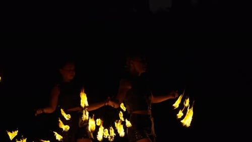 People Performing with Flames at Night