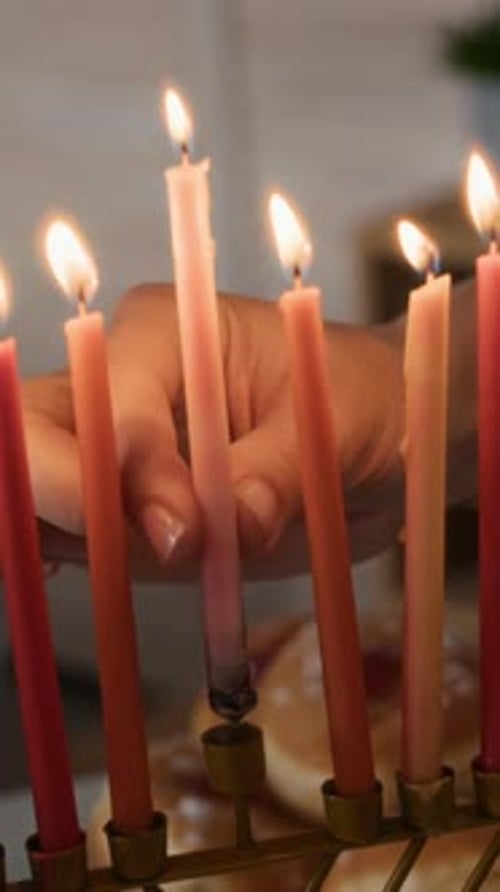 Hanukkah Candles Being Lit by a Hand
