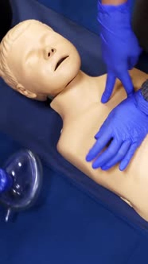 CPR Demonstration on Medical Training Doll with Gloves