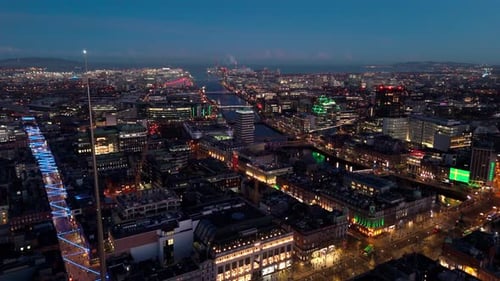 aerial landscape drone shot panning over Dublin cityscape with river Liffey at twilight blue hour