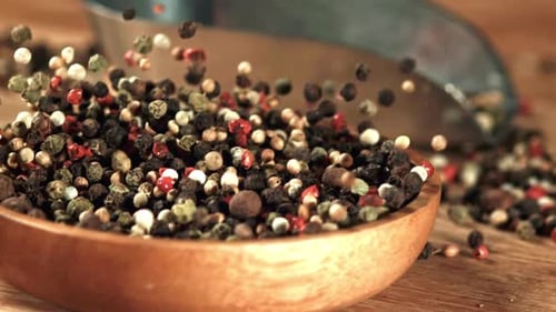 Mixed Peppercorns Filling a Wooden Bowl