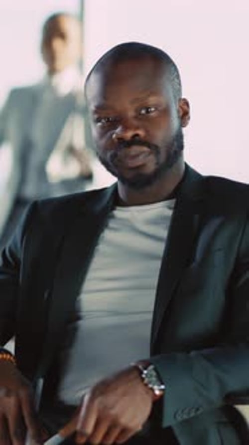 A Suited Man Sits in an Office Exuding Professionalism and Confidence