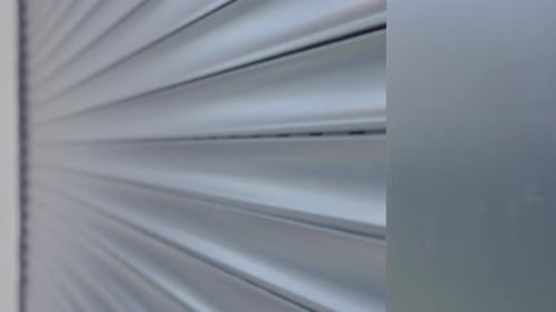 Modernes Fenster mit Rollladen, der an der Hausfassade schließt