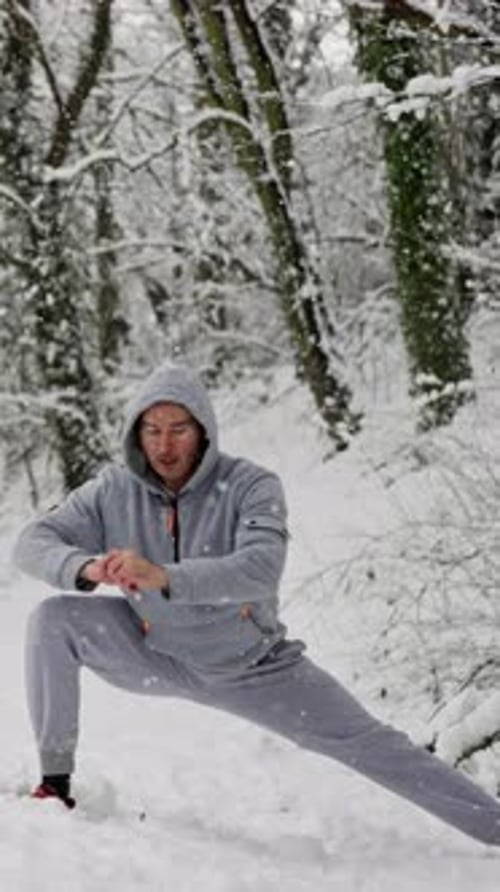 Man Stretching in Snowy Winter Forest