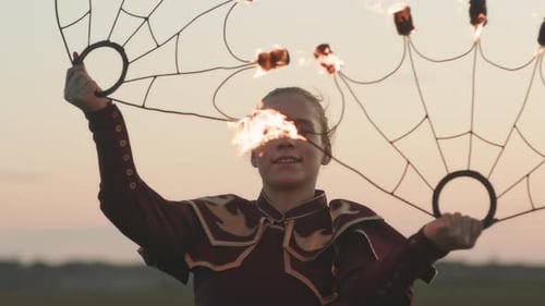 Young Adult Woman Performs Fire Dance at Sunset