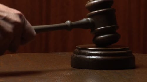 Gavel Strikes Sound Block on Wooden Table