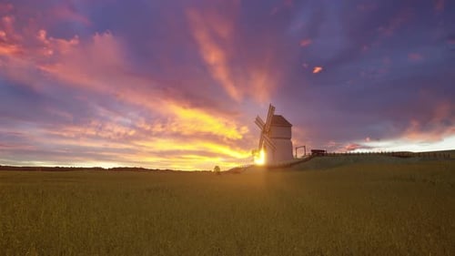 Dramatic Old Wooden Windmill on a Hillside Field at Fiery Sunset or Sunrise
