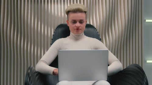 Femme caucasienne calme, fille, utilisatrice, tapant un ordinateur portable assis sur une chaise, ordinateur PC en studio blanc