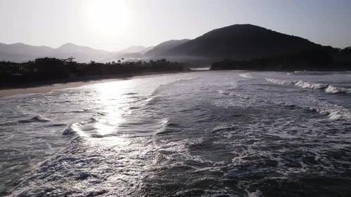 Static drone over the sea showing the shore in the morning.Fog at the atlantic rainforest at the bac