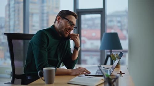 Smiling Man Talking on Phone in Modern Office