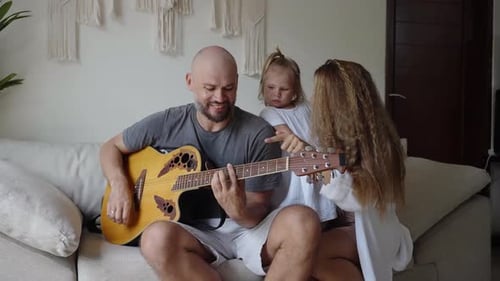 Father Playing Guitar with Daughter and Partner