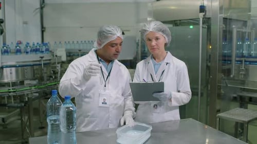 Spécialistes de laboratoire travaillant sur des échantillons d'eau et regardant une caméra