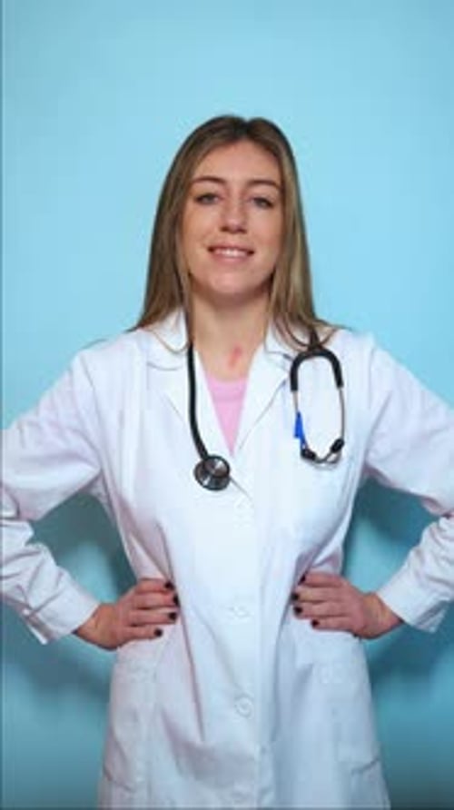 Smiling Young Woman in White Coat, Hands on Hips