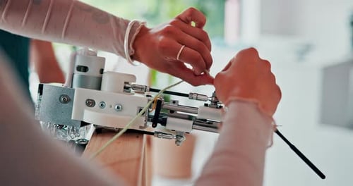 Hands, needle and threading yarn in tool in workshop and art class with safety in tuft studio
