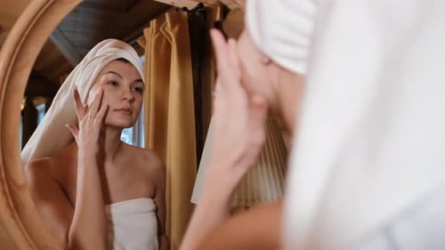 Close Up Portrait of Young Brunette Woman Looking in the Mirror After Shower at Home Facial Skin