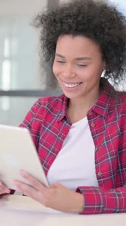 Mujer africana haciendo videollamada en tableta, vídeo vertical