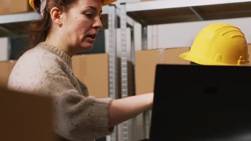 Warehouse Workers Reviewing Inventory on Laptop