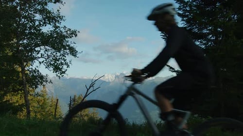 A cyclist pedals up a ridge with Mt-Blanc in the background