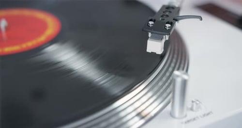 closeup of a black vinyl record on a player starting to rotate