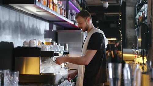 Young Man Cleaning Wine Glasses at Bar