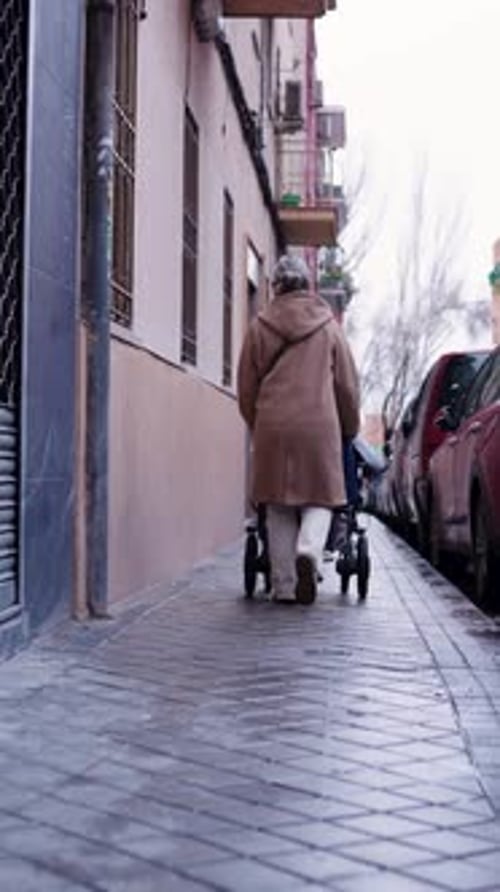 Senior Woman Walks on Sidewalk with Walker