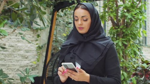 Portrait of Young and Confident Muslim Business Woman with a Smartphone in Hijab Middle Eastern