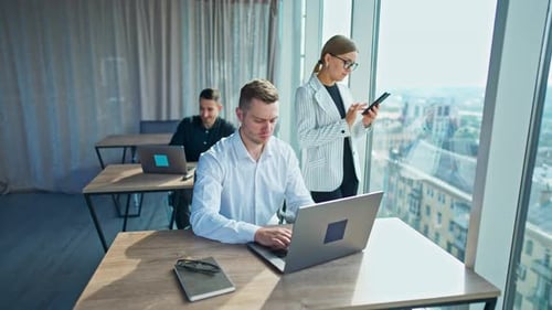Employees Working at Laptops in Modern Office