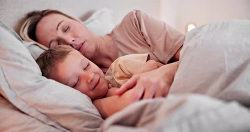 Woman and Boy Sleeping Together in Bed