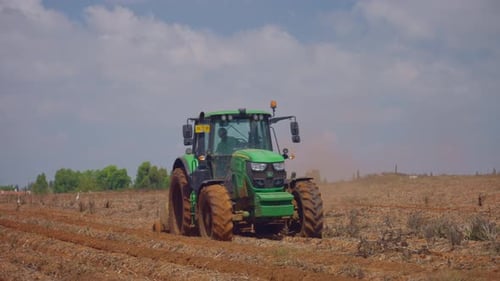 green tractor plowing a field2