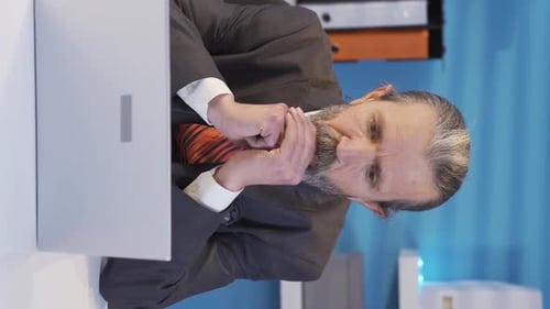 Stressed Businessman Working at Desk with Laptop