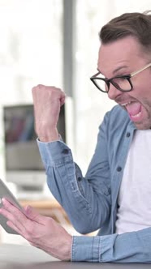 Excited Man with Tablet Celebrates Good News