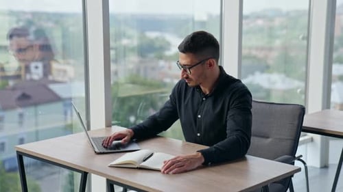 Young Man Working at Desk in Modern Office