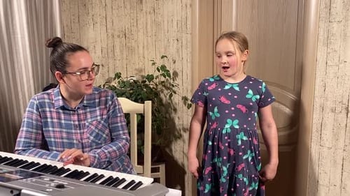 Girl Sings Along as Woman Plays Piano
