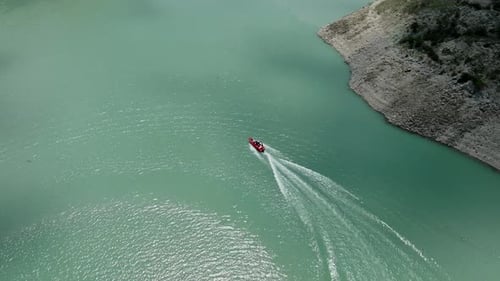 Motorboat Speeding Across Teal Waters From Above