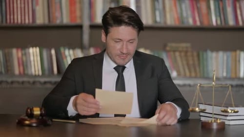 Excited Male Lawyer Reading Legal Documents in Office before Court