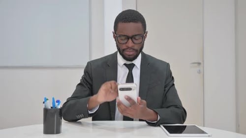 Man Uses Smartphone in Office, Wearing Suit