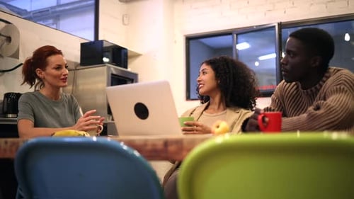 Three Young Adults Chatting Around a Table