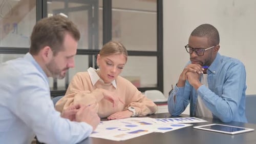 Young Mixed Race People Doing Paperwork in Office